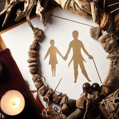 Shaman healing setup with natural elements and paper cutout of two figures representing shamanic ancestral healing